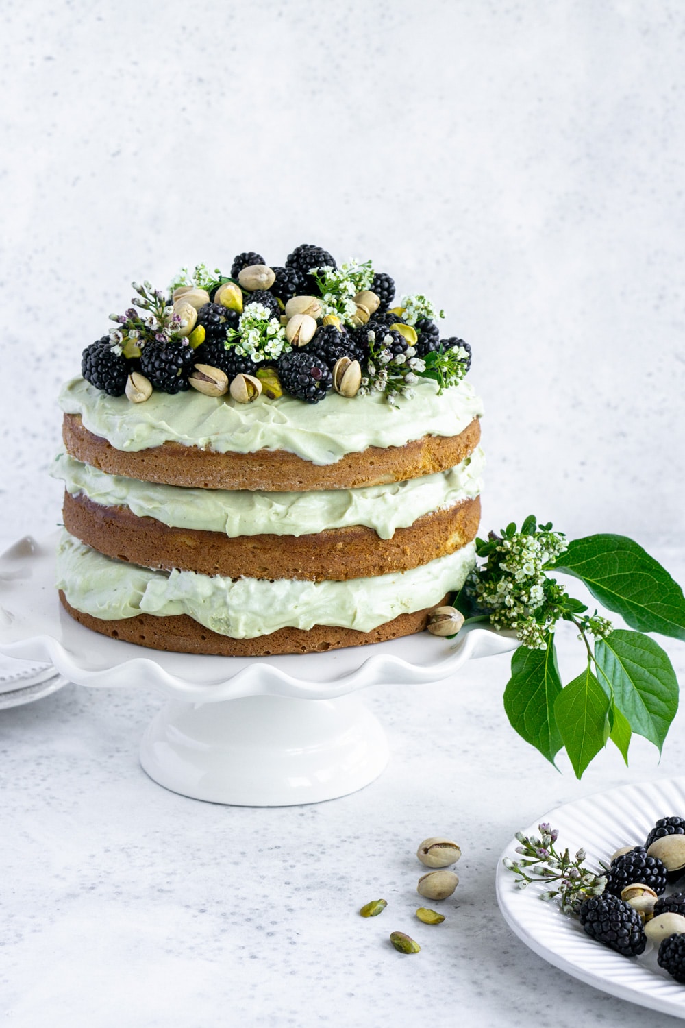 pistachio cake on a white cake stand