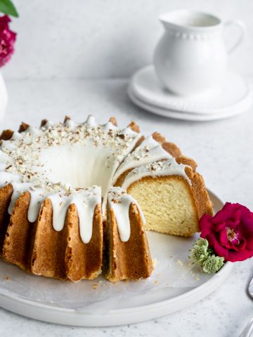 almond bundt cake on a plate with a slice taken out