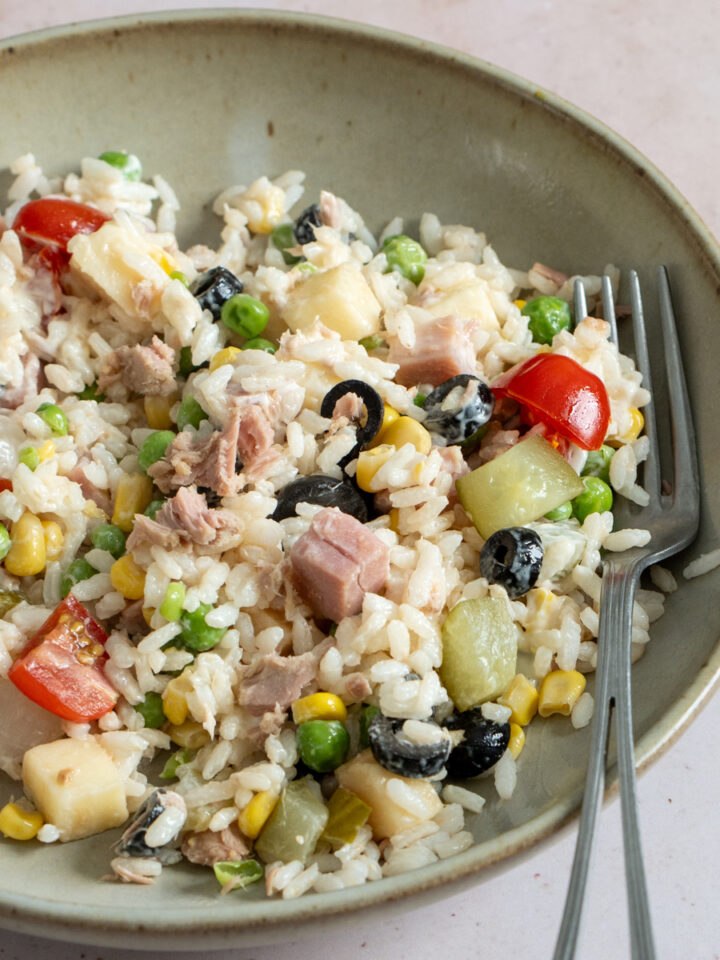 Italian rice salad with tuna, tomatoes, ham, olives and many other mix-ins in a dish