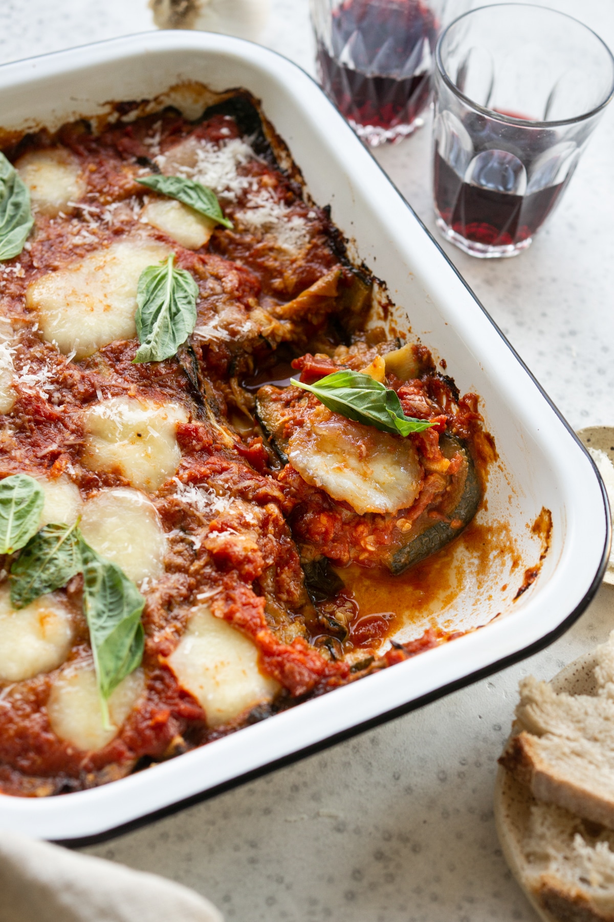 zucchini parmigiana in a baking dish with a slice cut out with