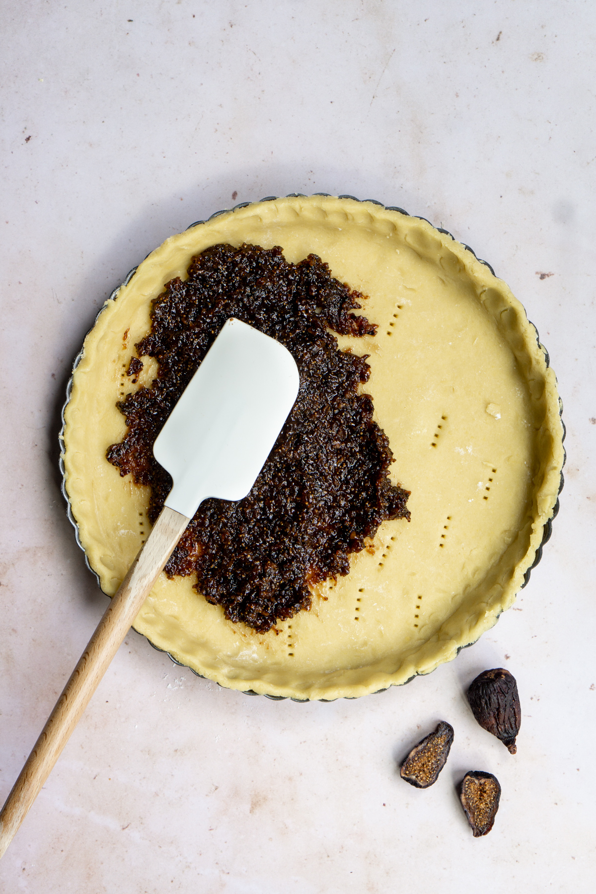 Fig jam in a tart shell with a spatula