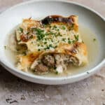 Lasagna in brodo in a plate topped with parmesan and parsley