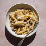 Pasta alla norcina in a plate with a fork in it