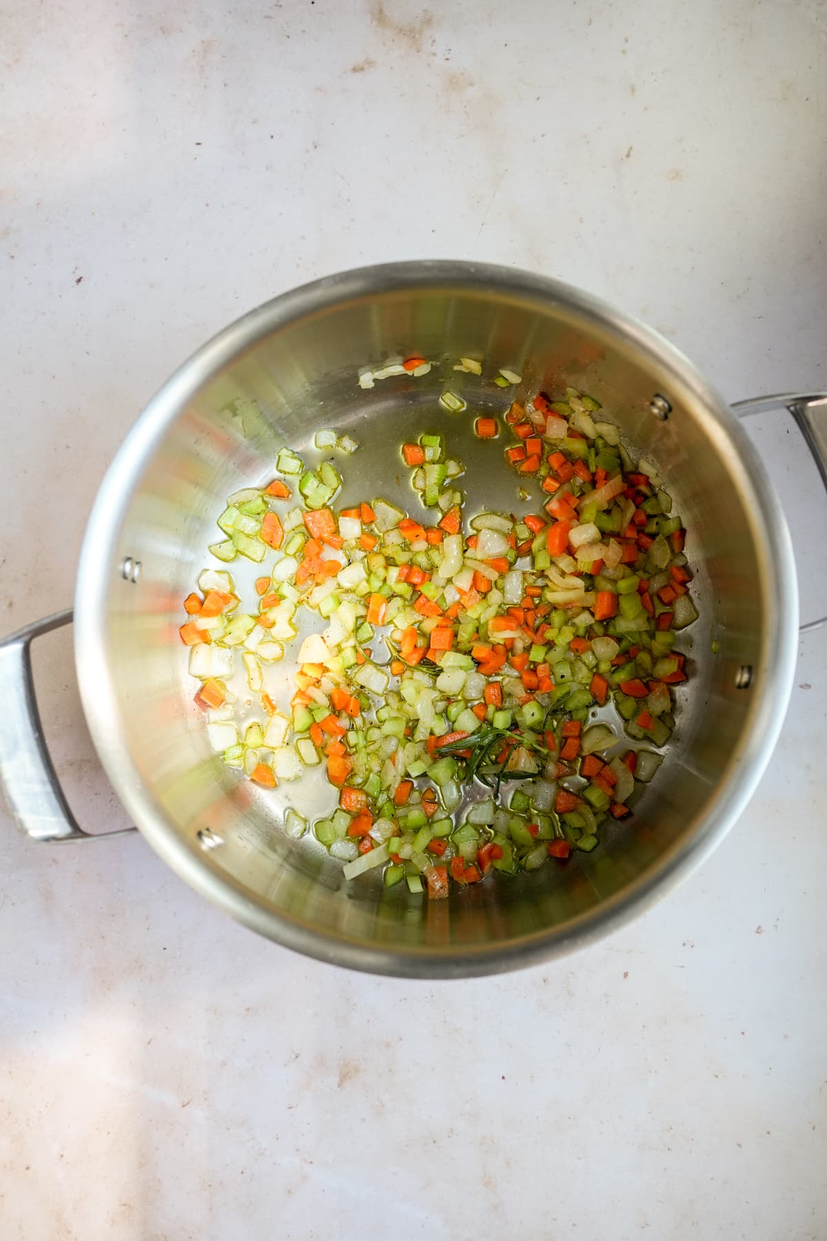 Chopped celery, carrot, onion and rosemary in a pot sauteed in olive oil