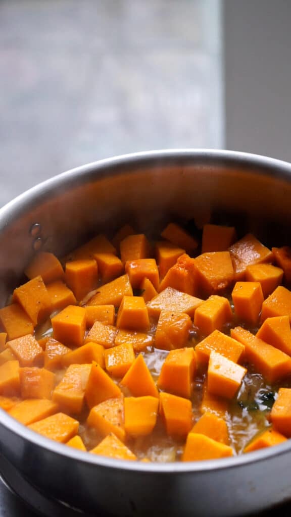 Cubed pumpkin in a pan with some hot water