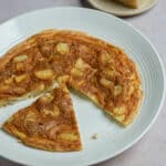 Potato frittata in a plate with a piece cut out