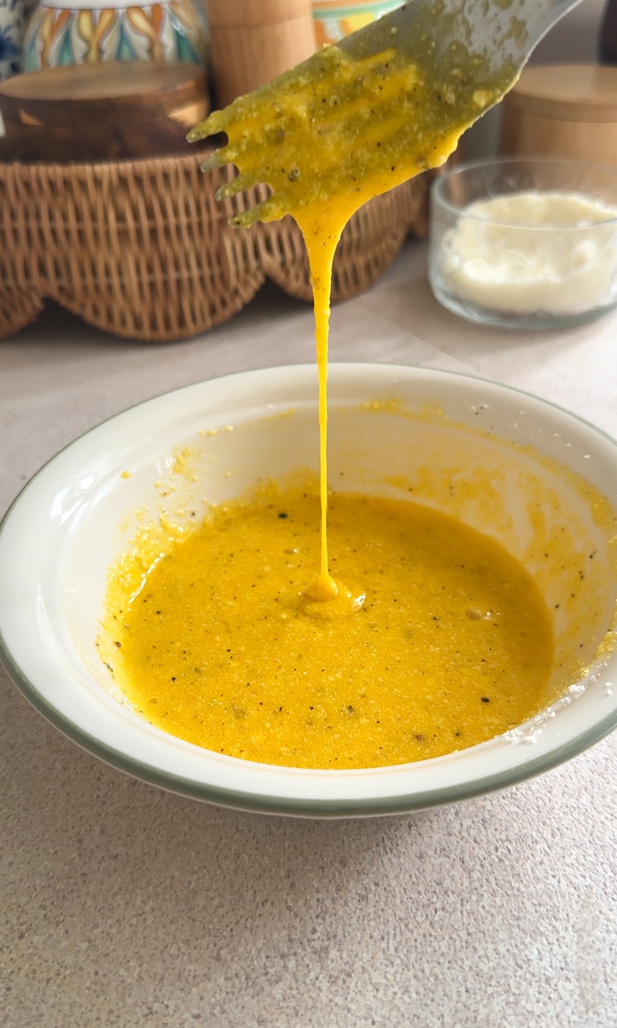Eggs beaten in a bowl with black pepper and parmigiano