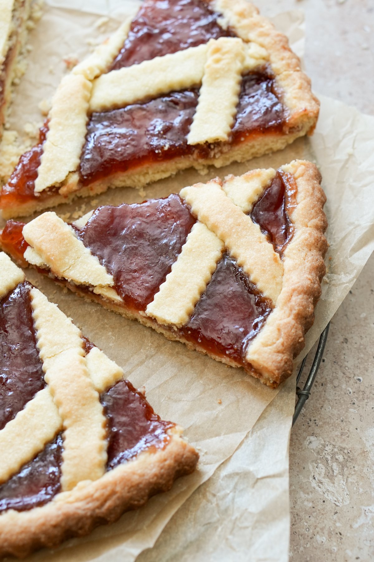 Two slices of crostata cut on parchment paper