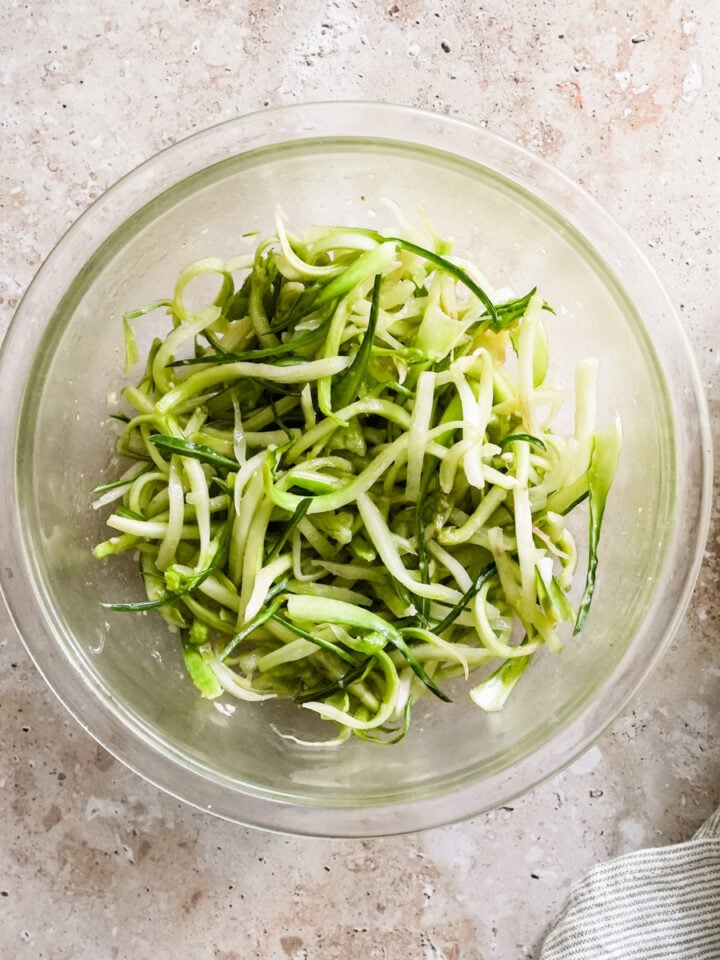 Puntarelle salad iin a glass bowl with a napkin to the side