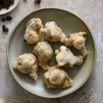 Zeppole covered in sugar in a shallow bowl