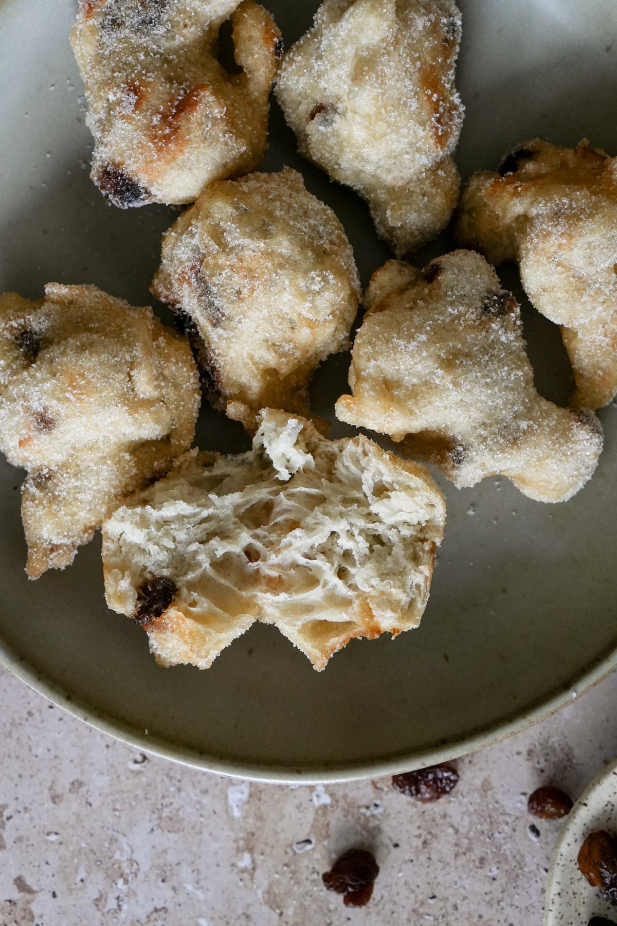 zeppole with raisins in a dish with one zeppola opened