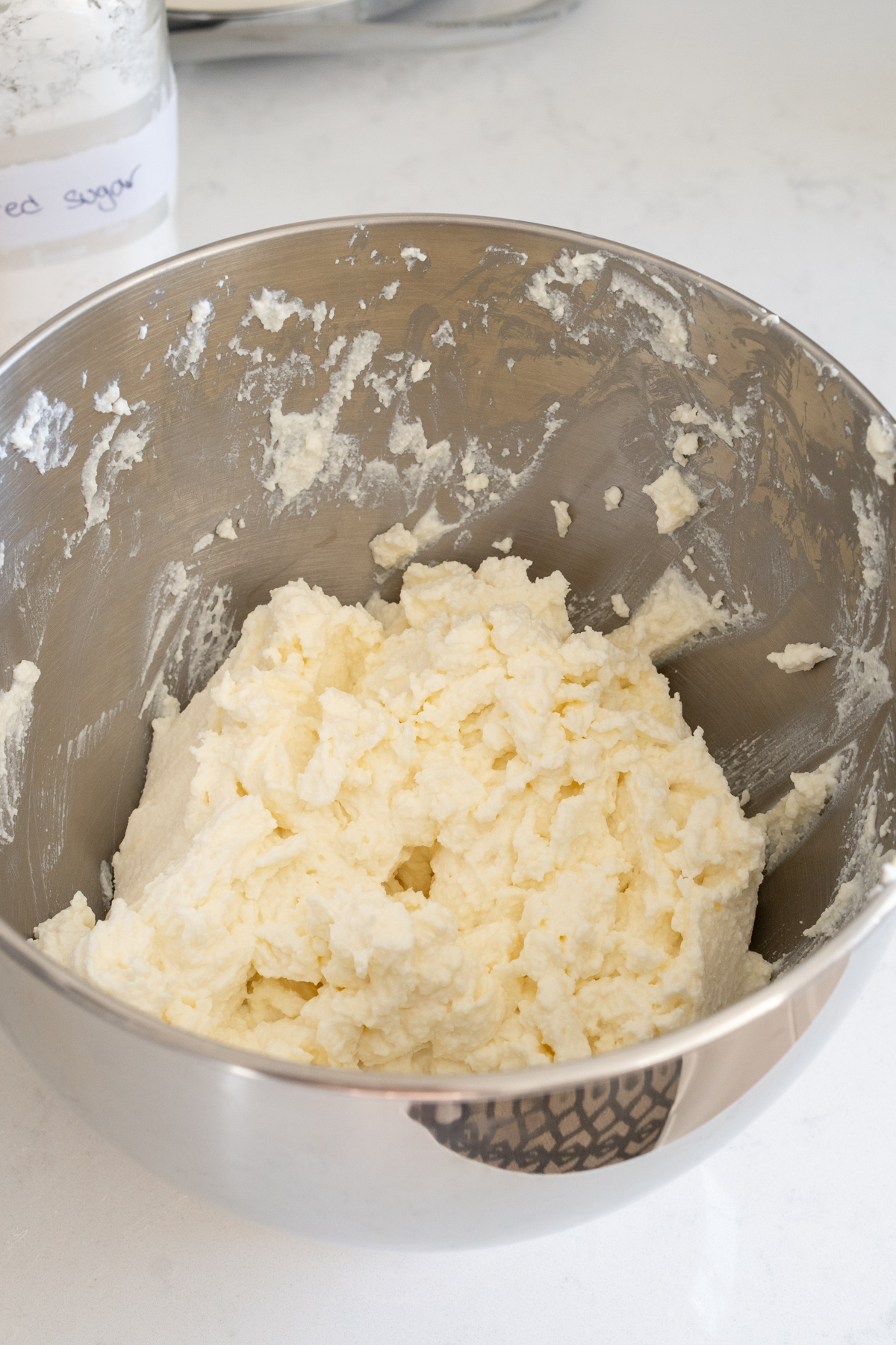 whipped ricotta and powdered sugar in the bowl of a stand mixer