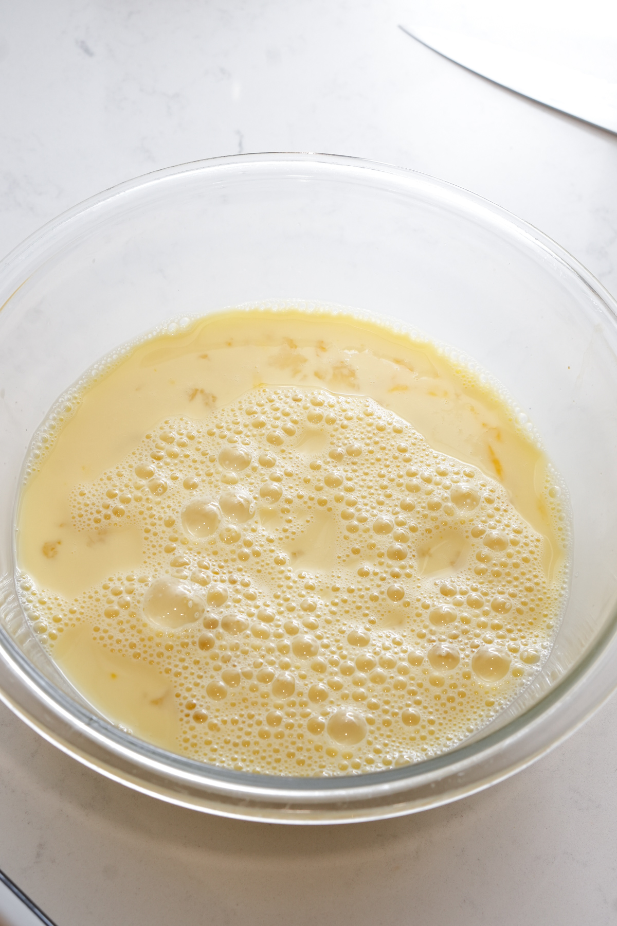 Beaten eggs and milk in a glass bowl