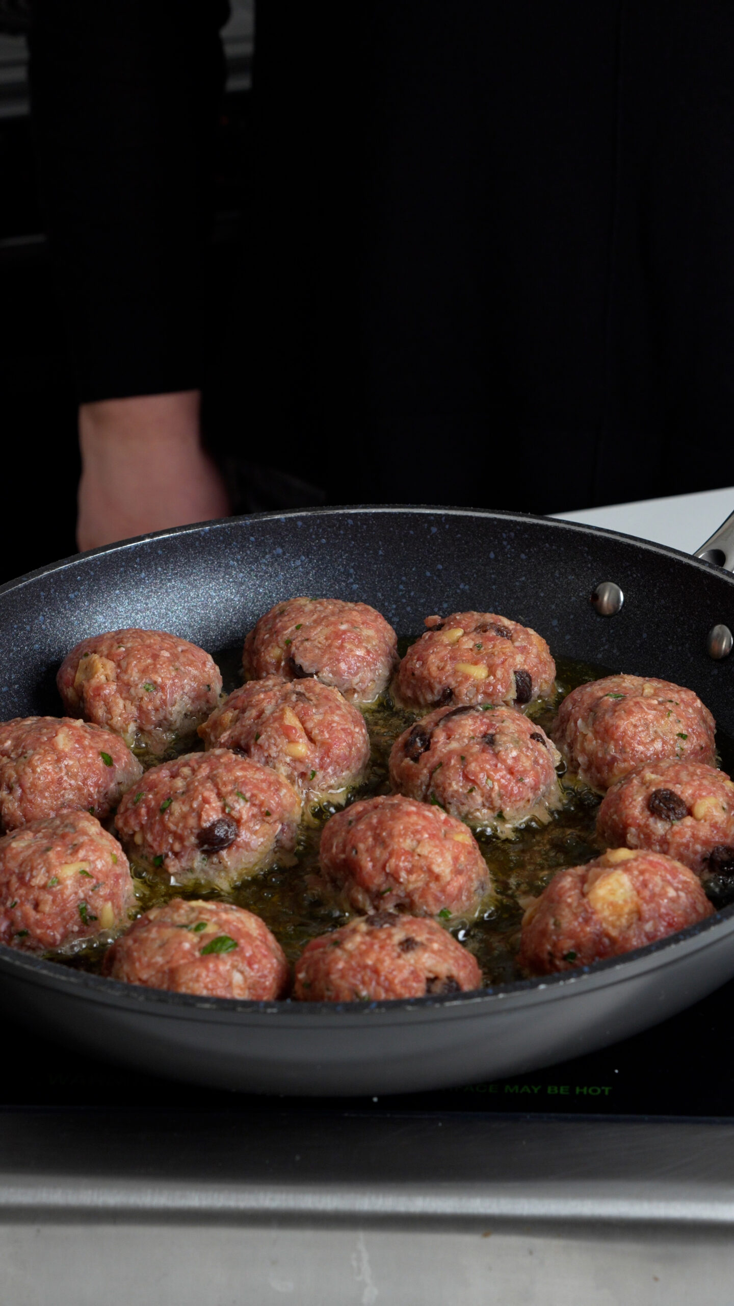 Meatballs being fried in a pan