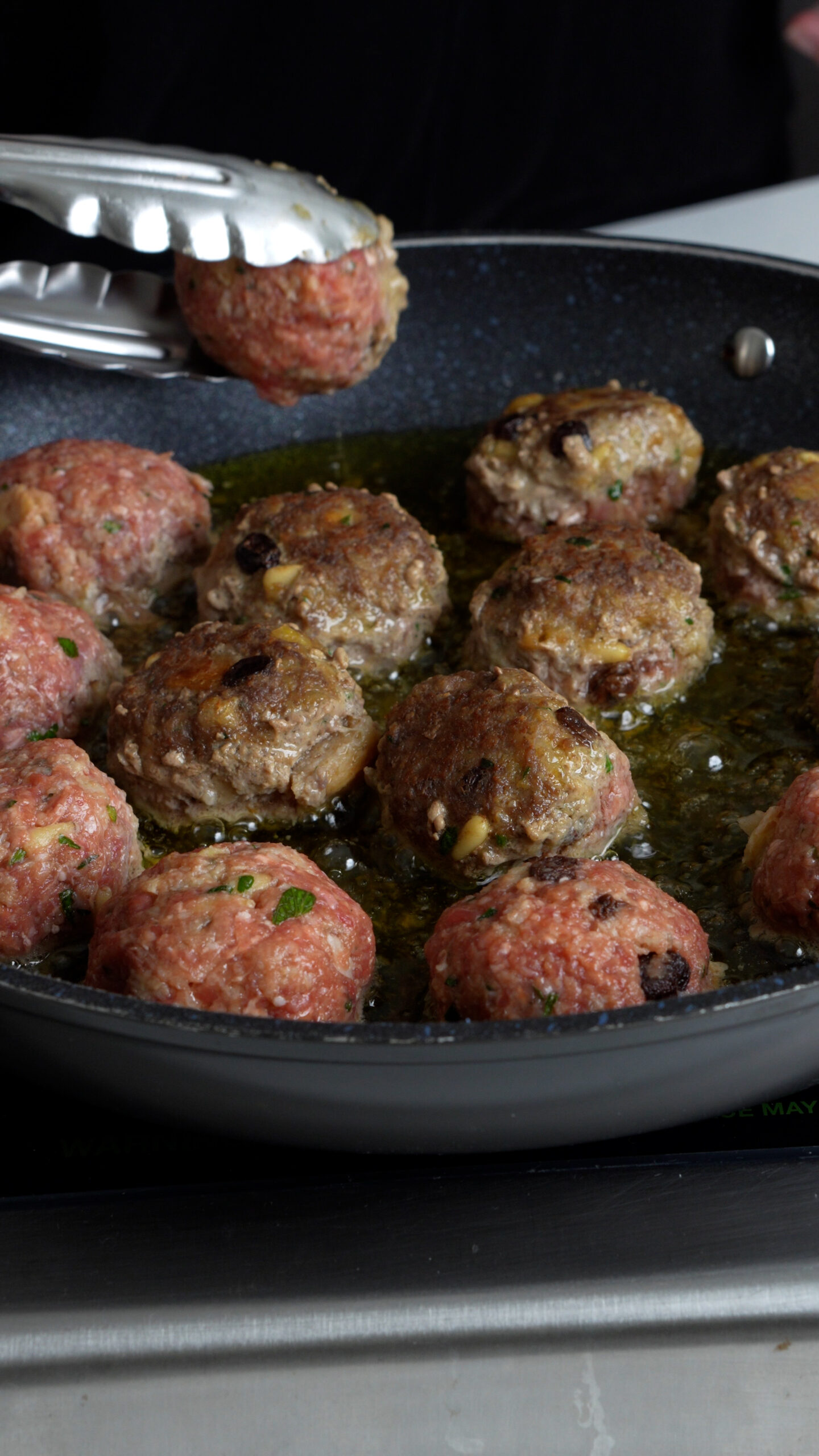 Meatballs being fried in a pan