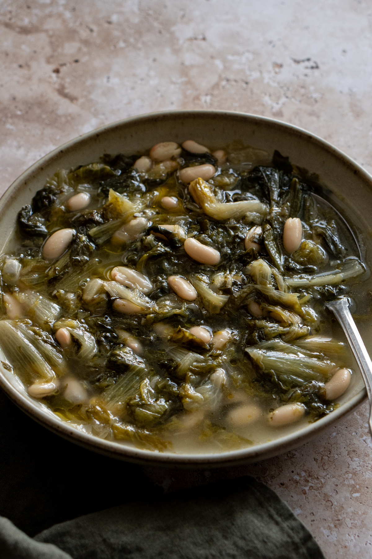 Escarole and beans in a bowl with a spoon