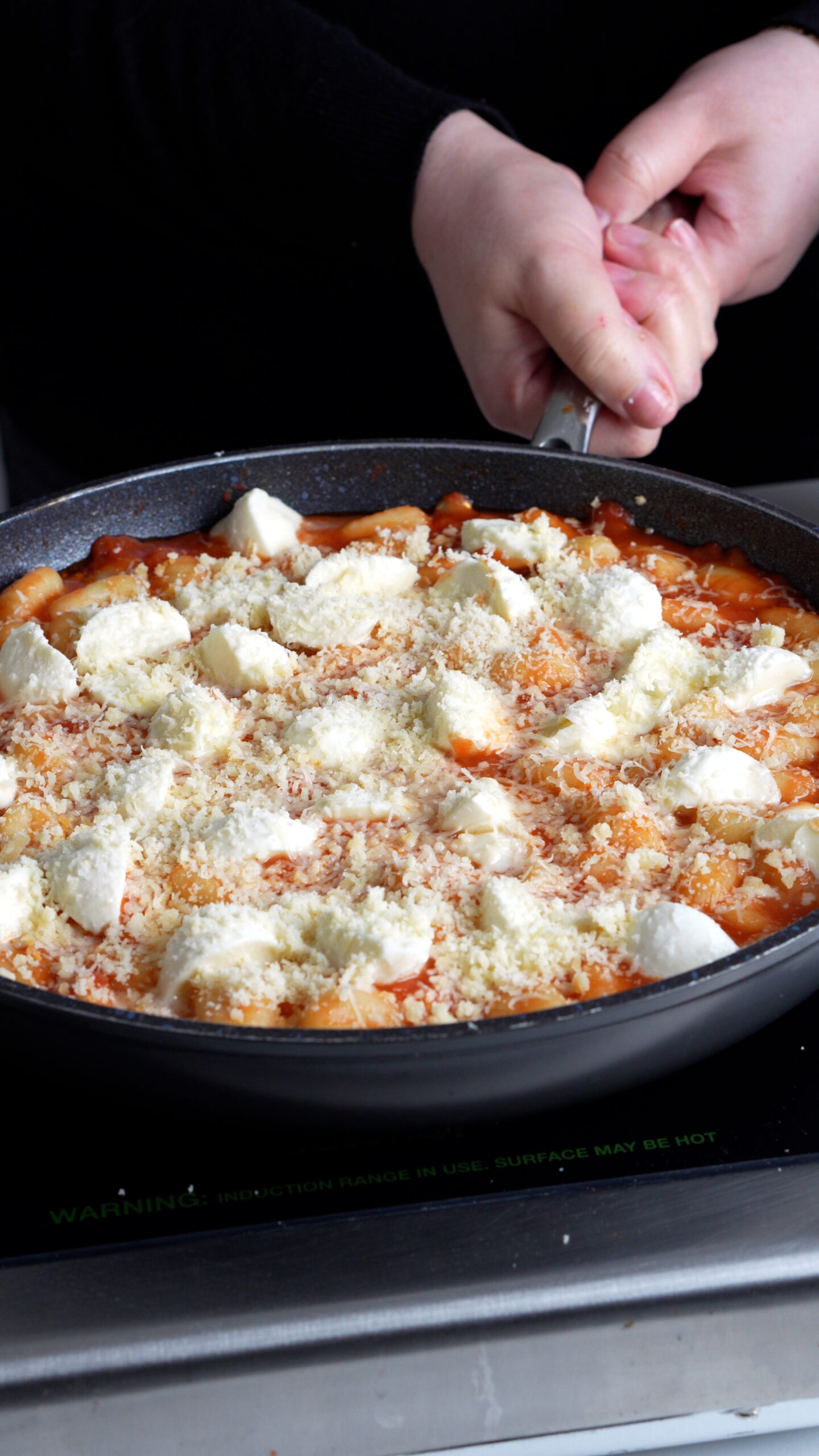 Gnocchi in a pan topped with mozzarella and grated parmigiano