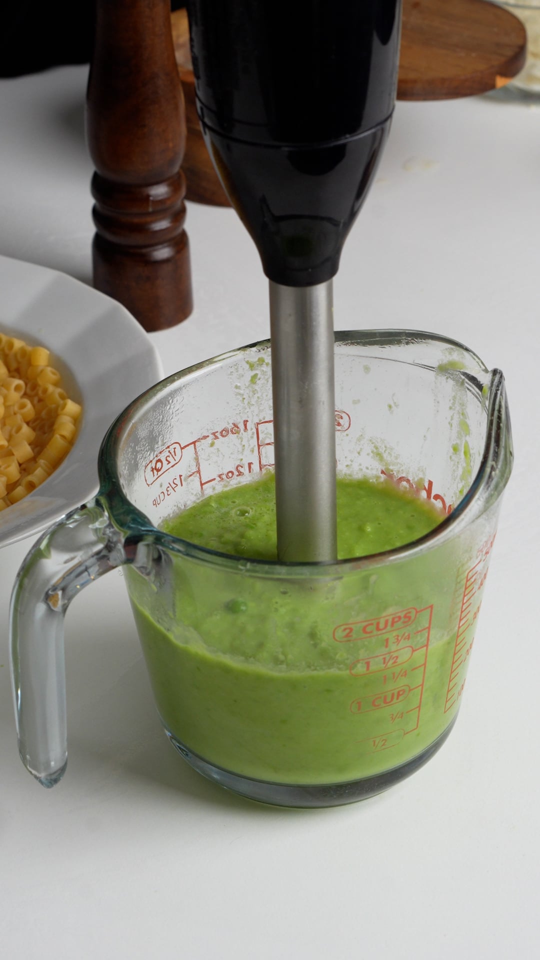 immersion blender blending up peas and water to make a puree