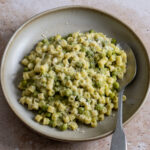 Pasta e piselli in a bowl with a spoon to the side