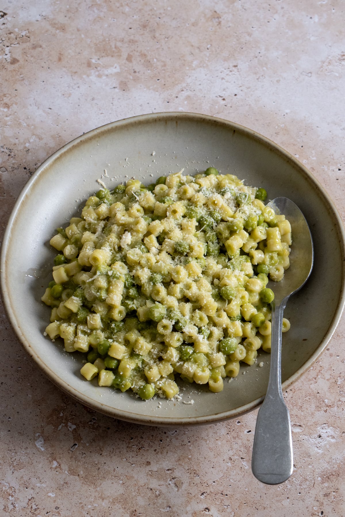 pasta e piselli in a bowl with a spoon