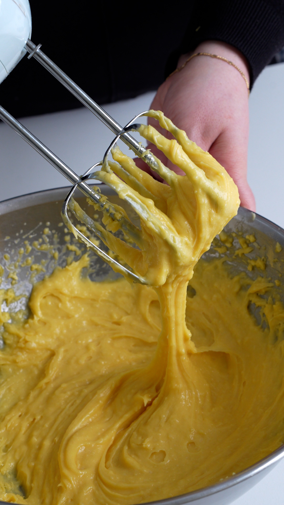 Zeppole dough in a bowl mixed with a hand mixer