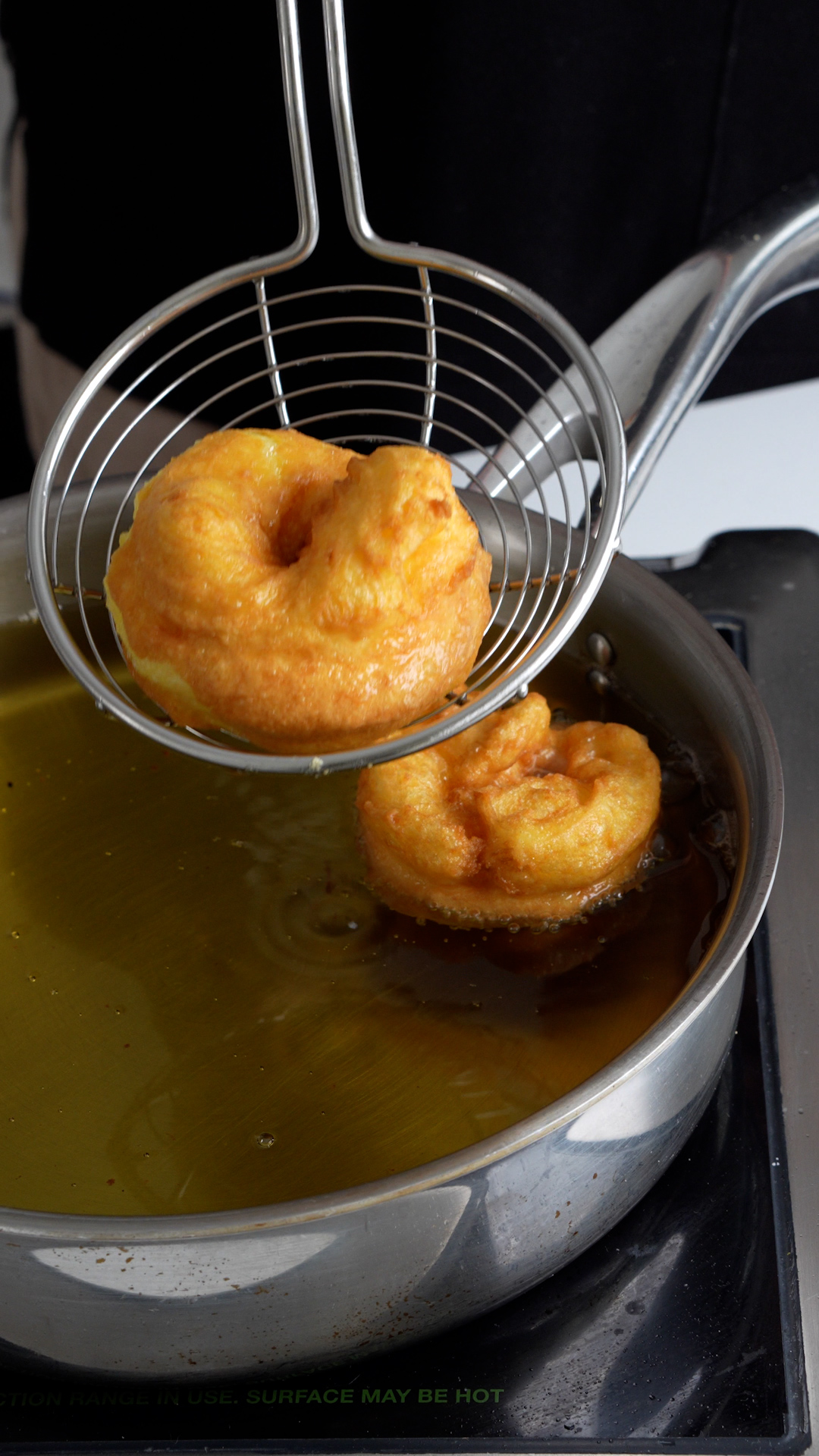 Finished fried zeppola being removed from oil