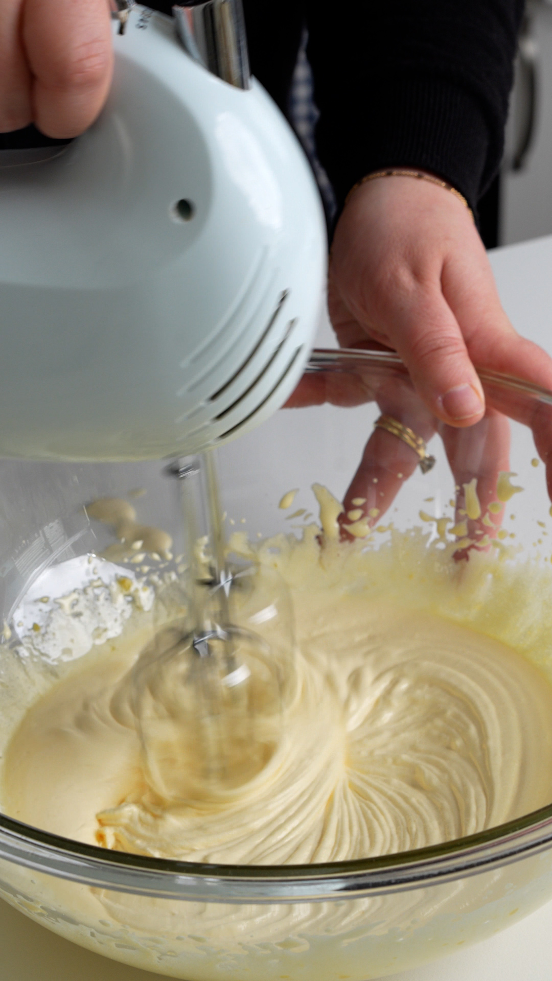 Egg yolks and sugar being mixed in a bowl with a hand mixer