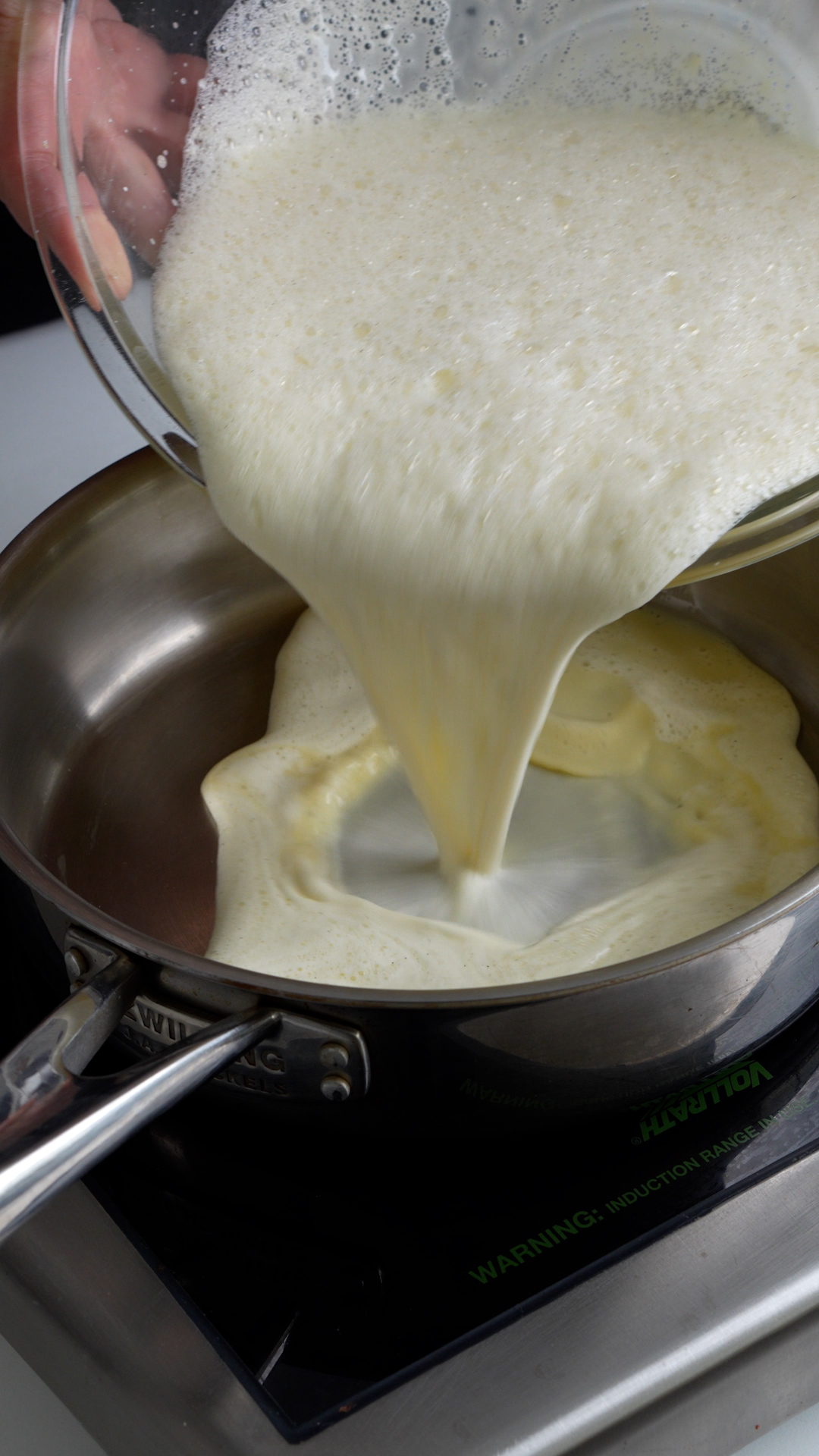 Milk and egg yolk mixture being poured into a pan