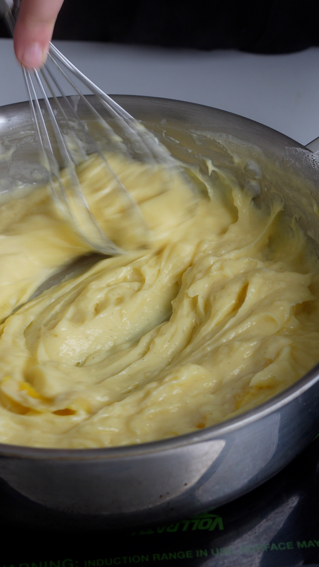 Pastry cream being whisked in a pan