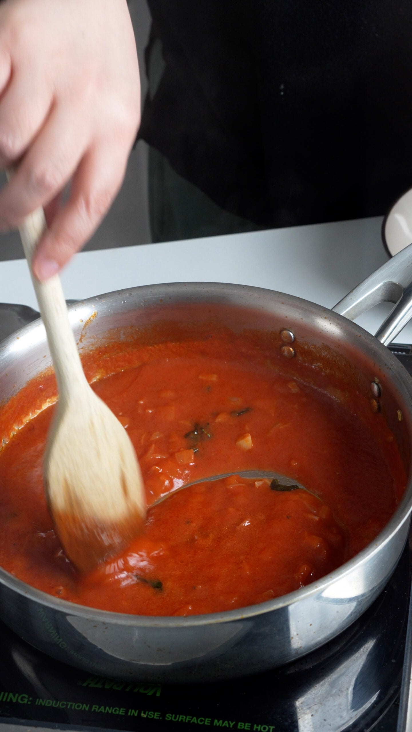 Tomato sauce being stirred in a pan