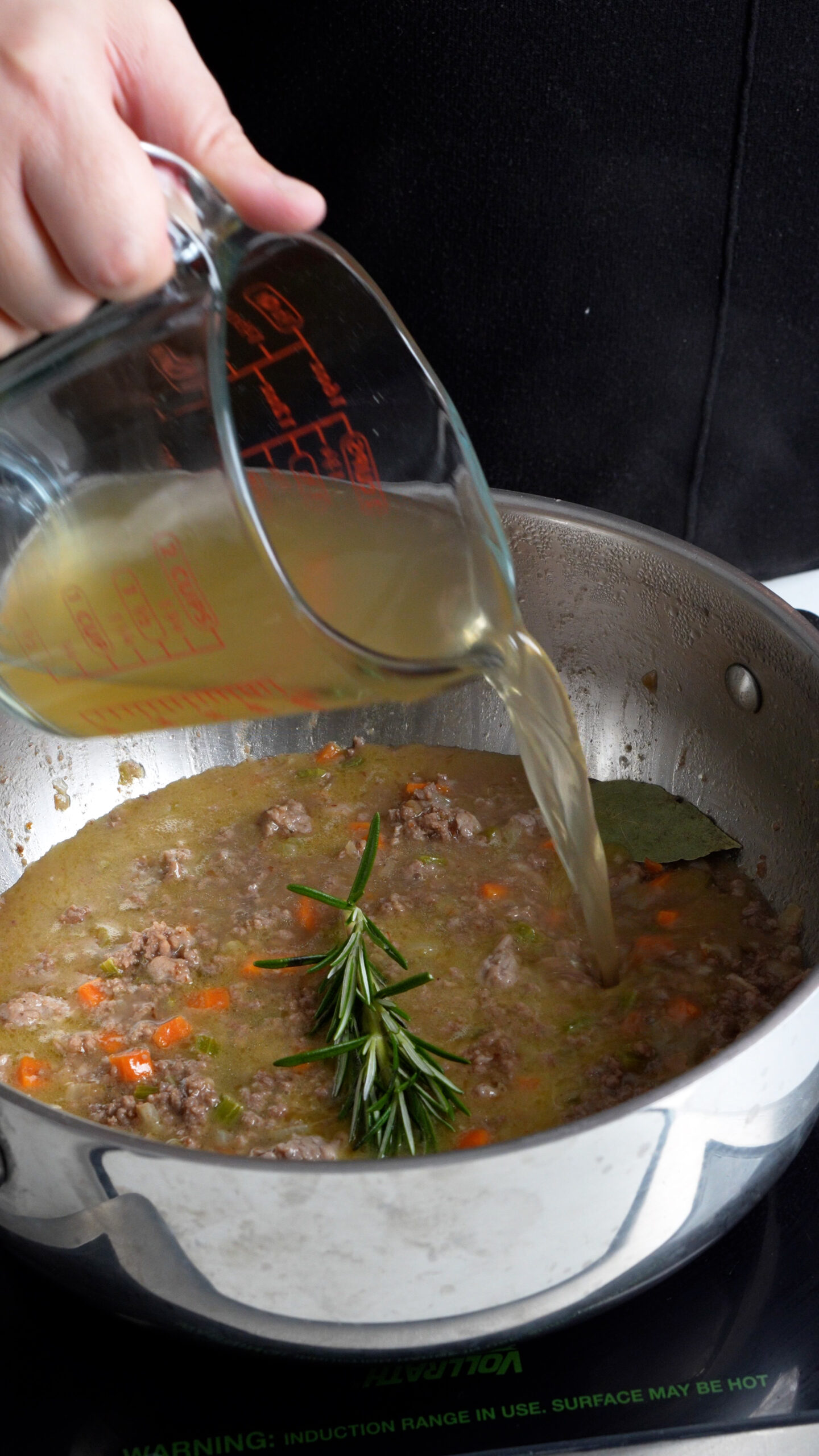 Beef stock being added to ragu bianco