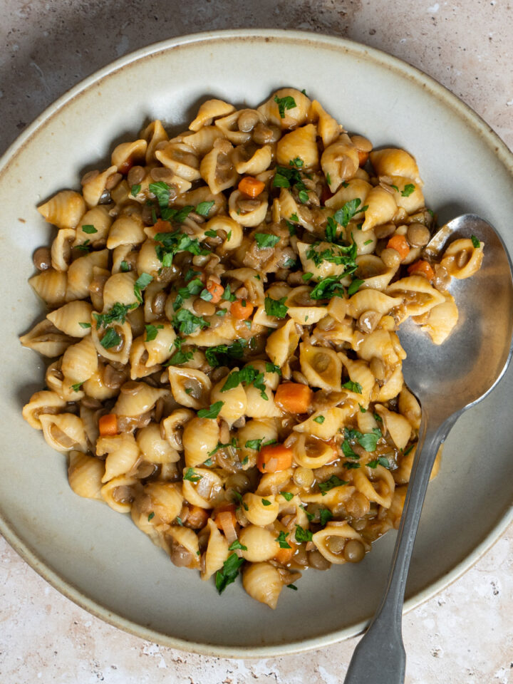 Dish of pasta and lentils topped with minced parsley