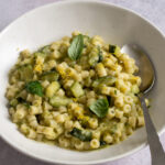 Pasta with zucchini in a bowl with a spoon to the side