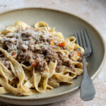 tagliatelle al ragu bianco in a plate with a fork
