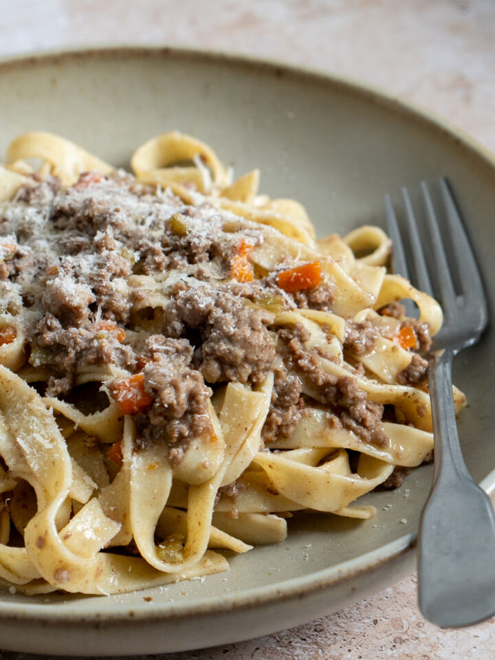 tagliatelle al ragu bianco in a plate with a fork