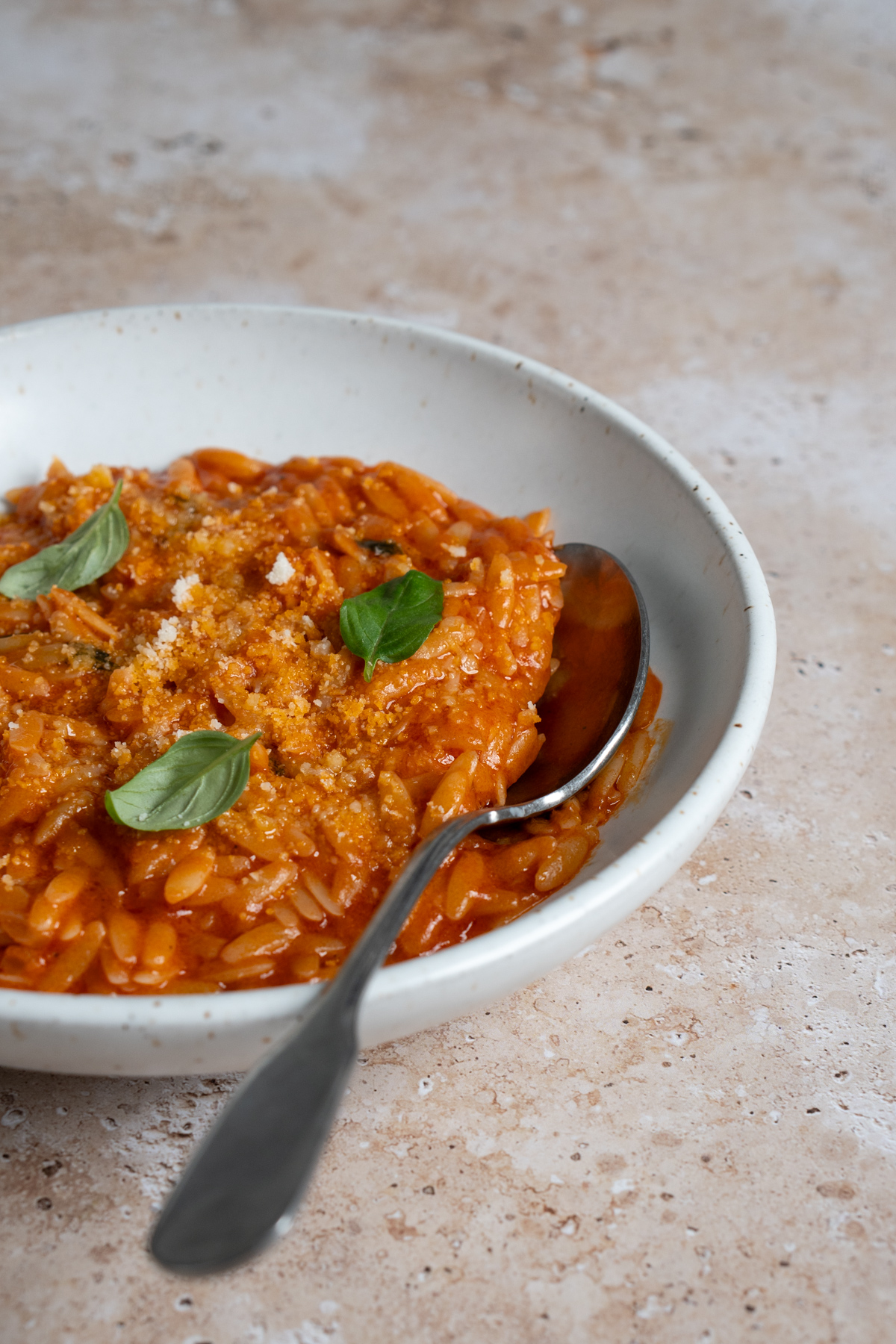 Bowl of tomato pastina with a spoon