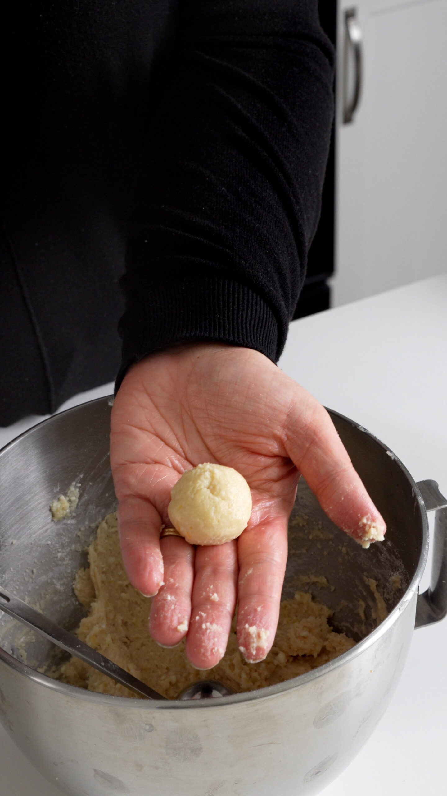 Ball of lemon ricotta cookie dough in a hand