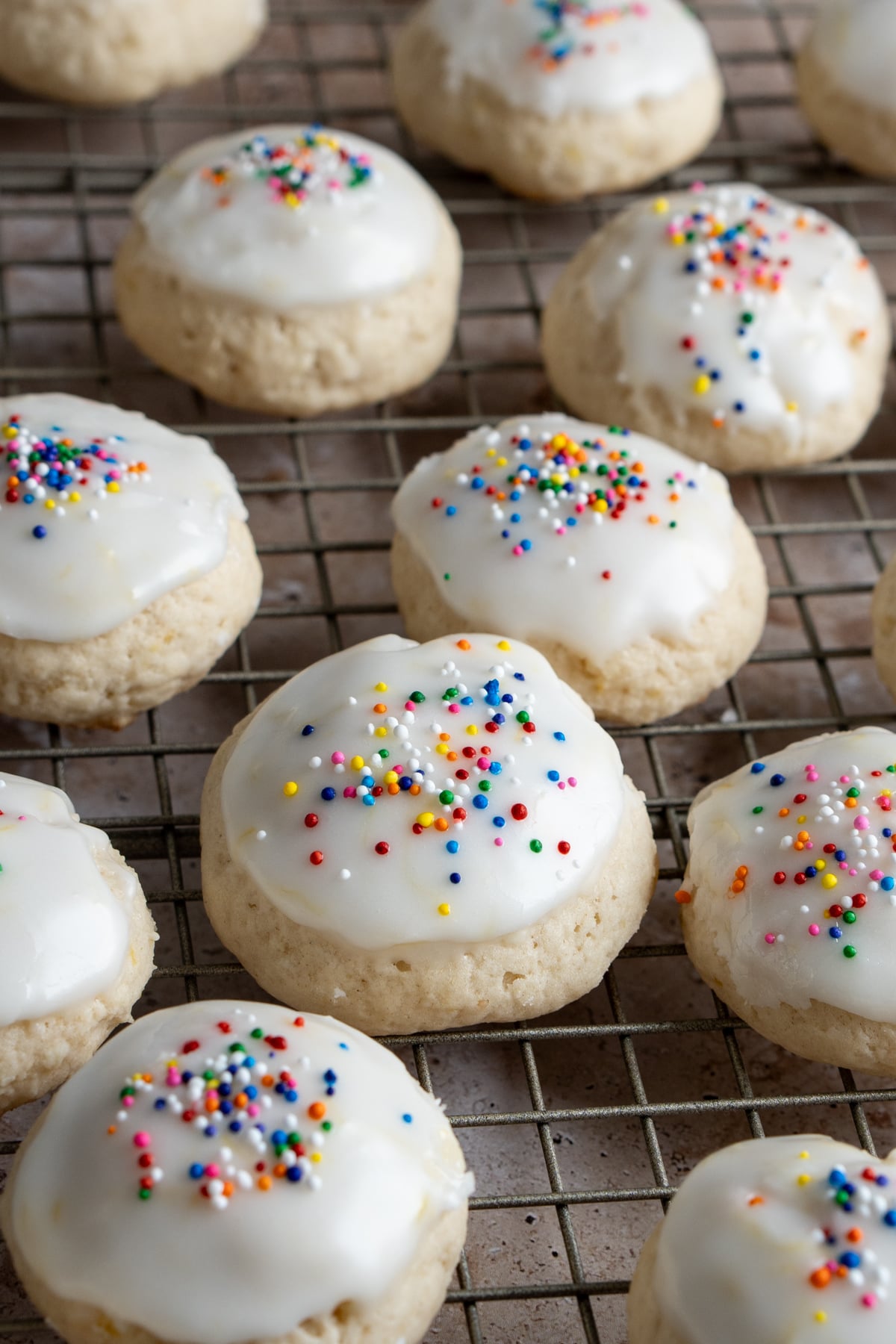 Lemon ricotta cookies with lemon glaze and sprinkles on a cooling rack