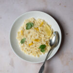 Plate of pasta al limone topped with fresh basil and grated parmigiano