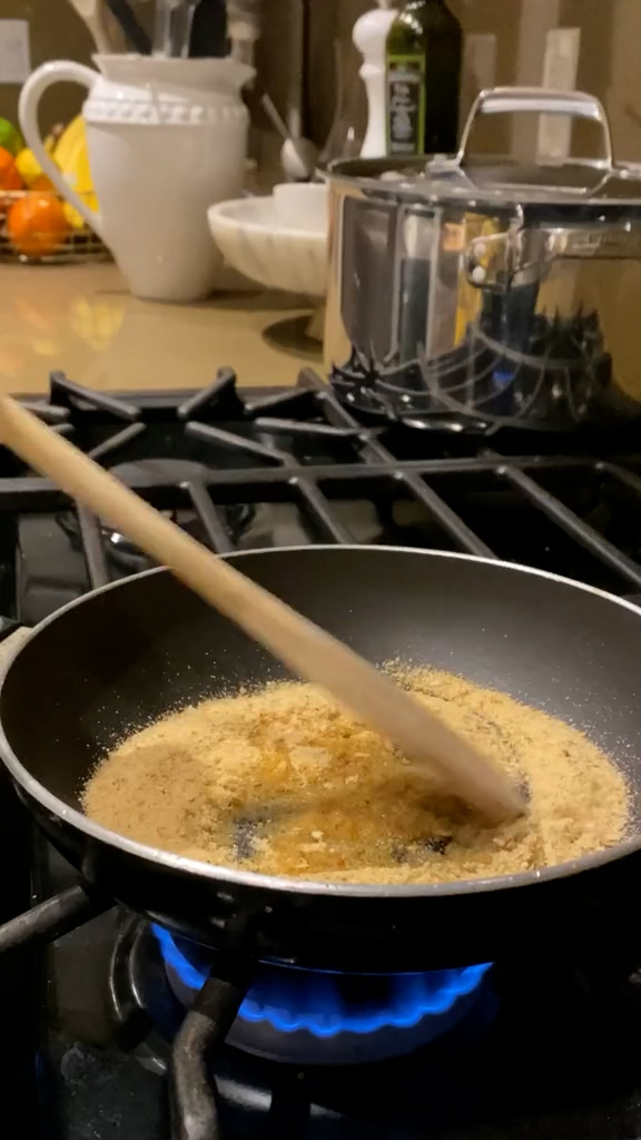 Bread crumbs being toasted in a pan with olive oil
