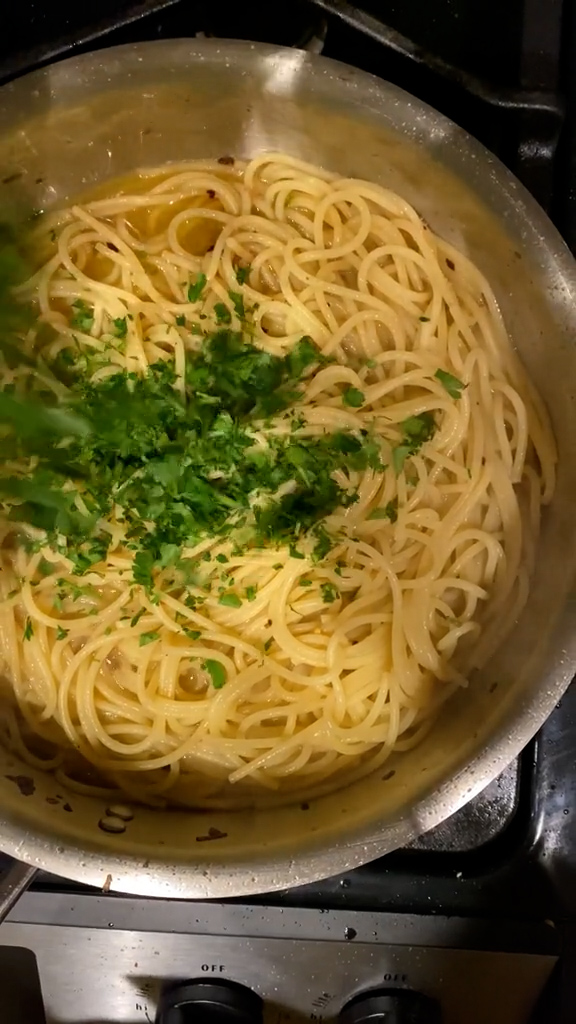 Minced parsley in a pan with spaghetti