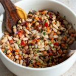 bean salad in a bowl with serving spoons
