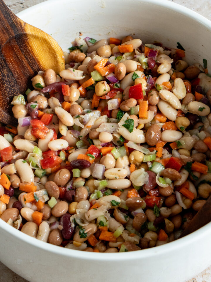 bean salad in a bowl with serving spoons