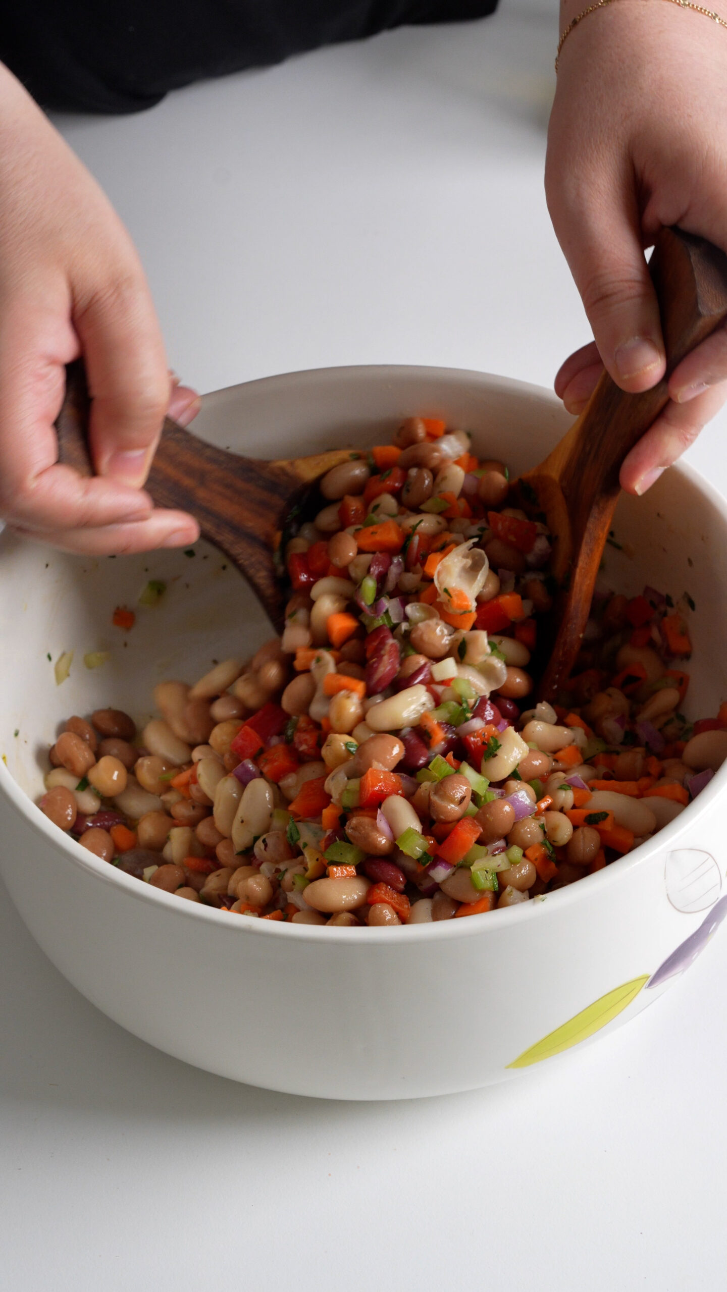 Bean salad being mixed in a bowl
