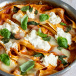 one pot lasagna in a pan with fresh basil