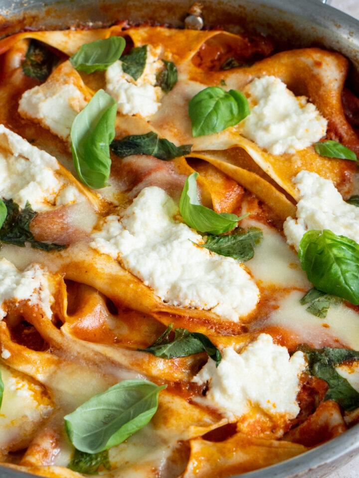 one pot lasagna in a pan with fresh basil