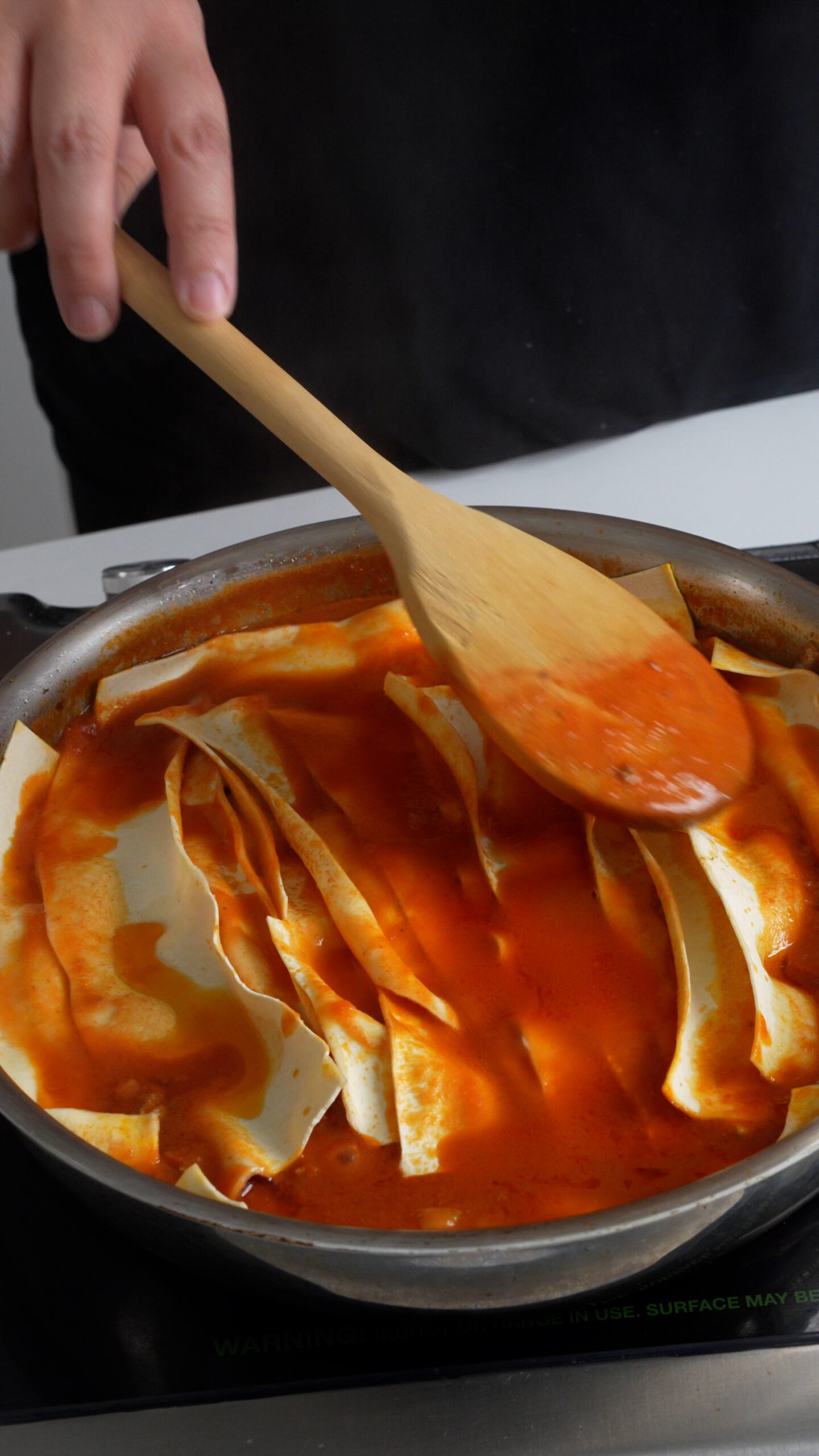 Lasagna sheets laying flat in a pan with tomato meat sauce