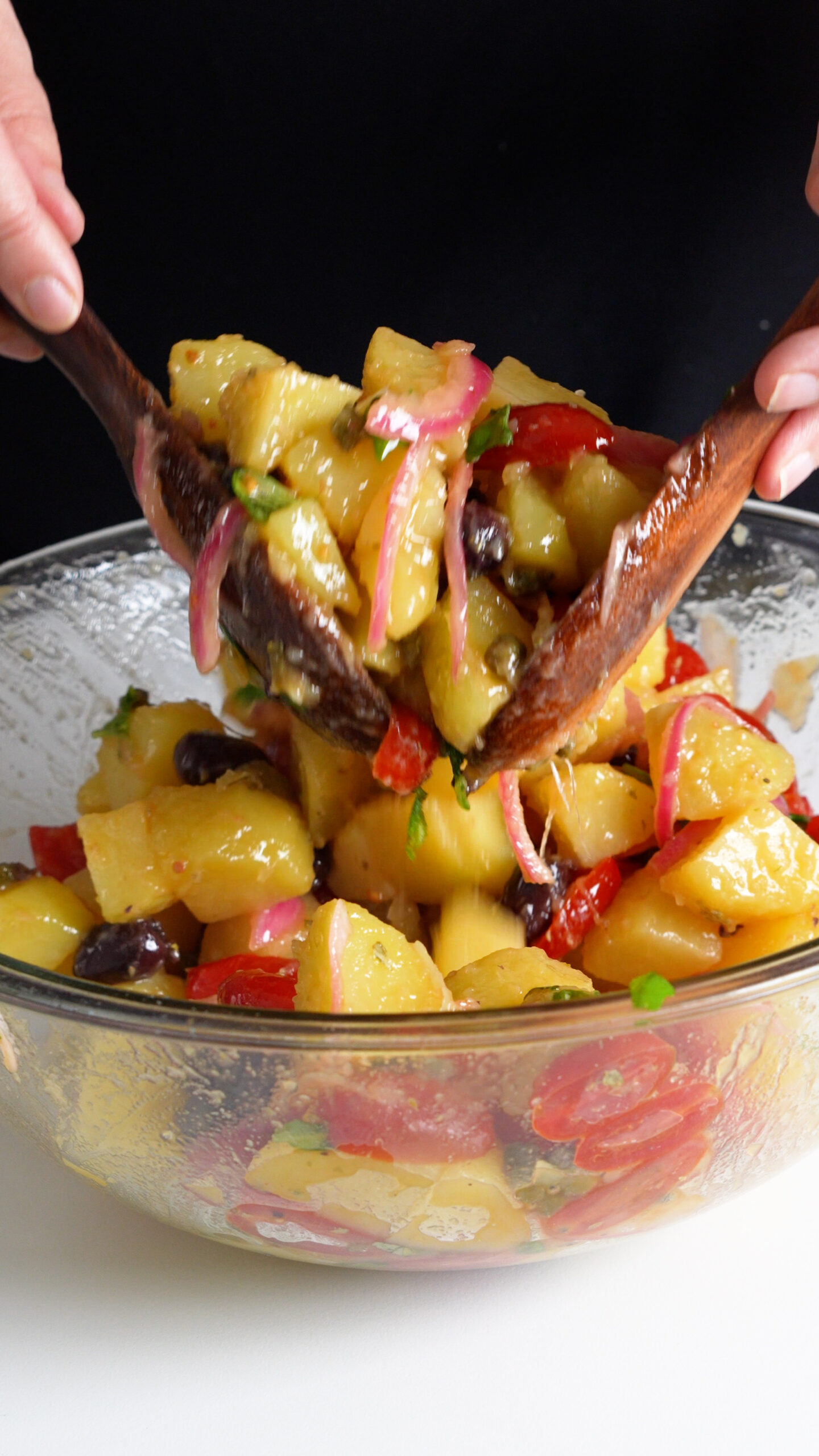 Italian potato salad in a bowl being tossed