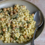 chick pea and zucchini pasta in a bowl with a spoon in it
