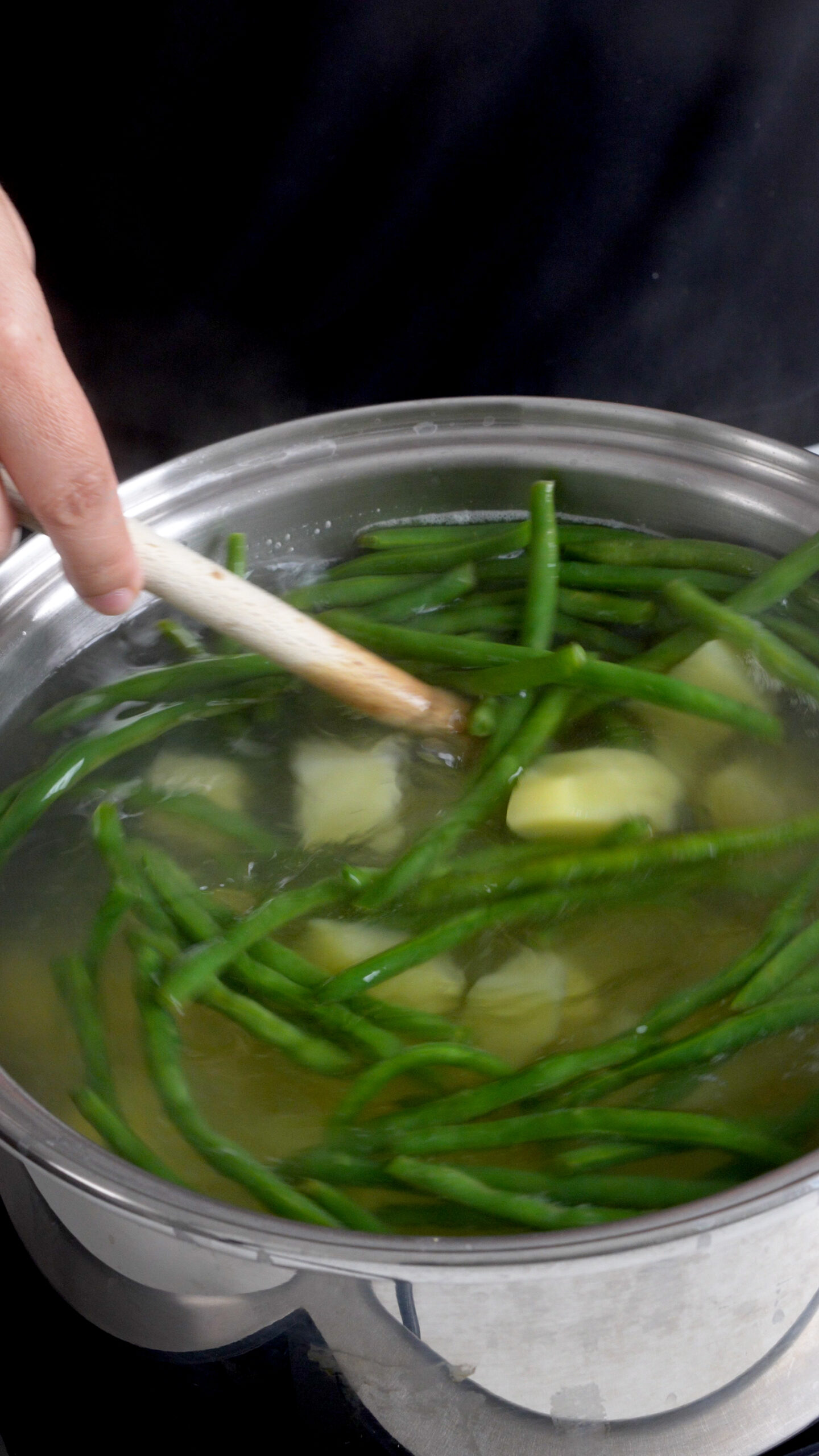 Boiling potatoes and green beans in a large pot